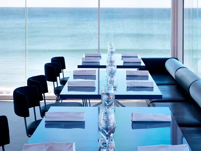 Modern table setting with glassware and folded napkins in a coastal restaurant setting