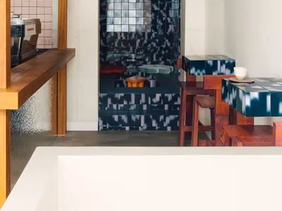 Modern industrial interior design with concrete walls and wooden furniture in a restaurant setting.