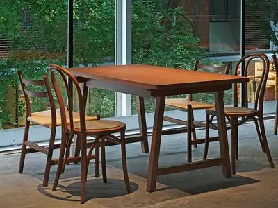 An industrial-style restaurant featuring wooden furniture and a glass exterior.