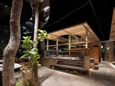 Modern industrial restaurant interior with exposed wooden beams and concrete floors.