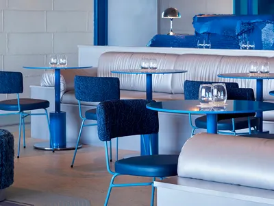 Modern restaurant interior with blue accents and fixtures.