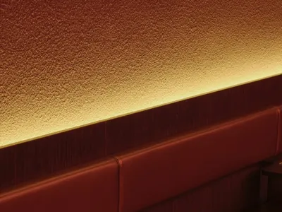 Modern red leather booth with small table and backlit wall