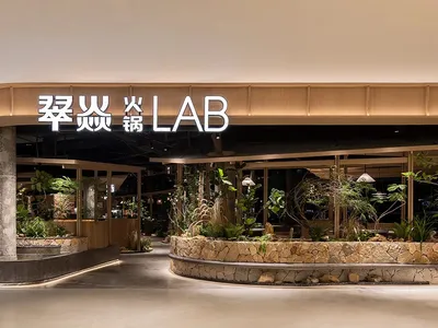 Modern restaurant entrance featuring stone and concrete interior design.