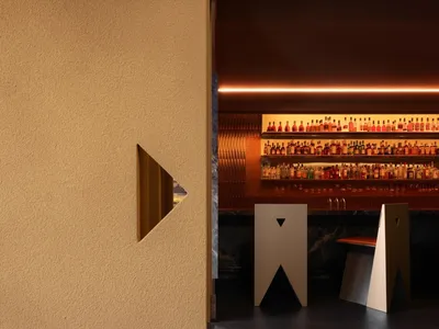 An industrial-style restaurant/bar interior with minimalist design elements.