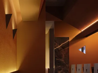 Modern restaurant interior with warm lighting and geometric shapes.