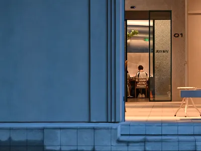 A modern, industrial-style restaurant entrance with metallic accents and a red heart-shaped window.