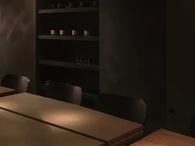 Minimalist restaurant interior featuring concrete and wooden elements.