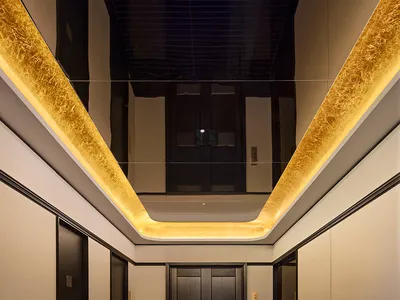 Modern hotel hallway featuring a sleek elevator lobby with contemporary designs.