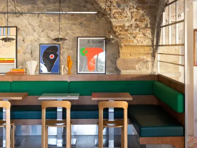 Modern restaurant interior with stone walls and contemporary seating.