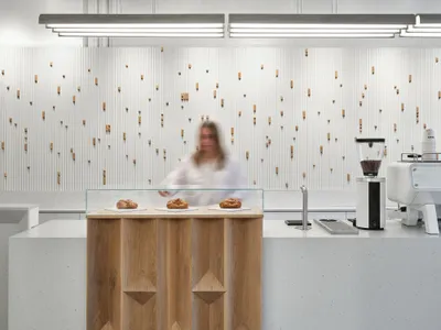 Modern cafe counter with minimalist design and natural materials like wood and concrete.