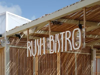 Bamboo exterior design of a restaurant with the sign 'Rush Bistro'.