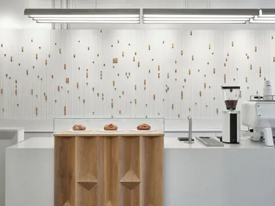 A minimalist restaurant counter featuring wood and concrete materials.
