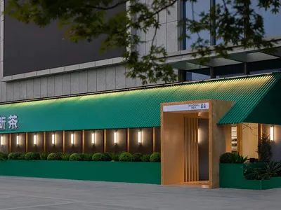 現代餐廳外觀，搭配綠色金屬屋頂與發光招牌。