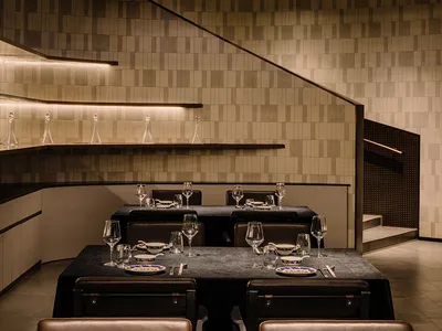 Modern restaurant interior with concrete walls and minimalist design.