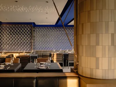 Modern, spacious restaurant interior with furniture layout featuring wood, tiles, and concrete elements.