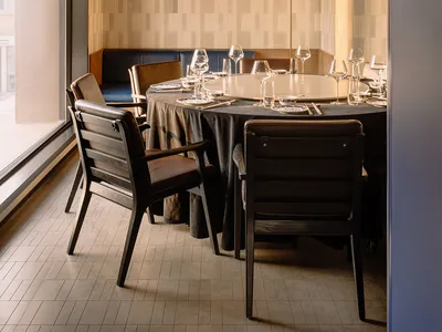 Modern interior design of a restaurant featuring wooden furniture, glass tableware, and tiled walls