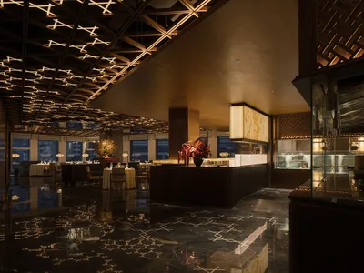 An elegant restaurant interior featuring modern design, marble finishes, and sophisticated lighting