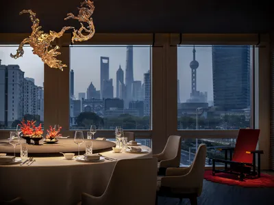 Industrially designed restaurant with glass chandeliers and a cityscape view.