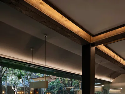 A sophisticated Japanese restaurant interior with dark wood and glass elements, featuring traditional furnishings and a seren