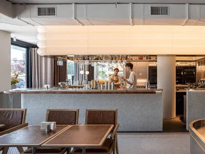 A photograph of a modern restaurant interior featuring tile and metal finishes.