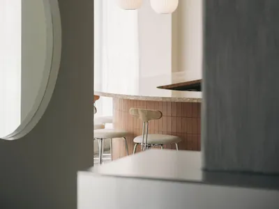Modern, white-concrete restaurant interior with minimalist design.