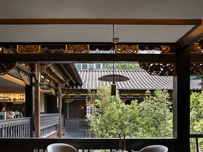 A modern restaurant interior with a stone table and white chairs.