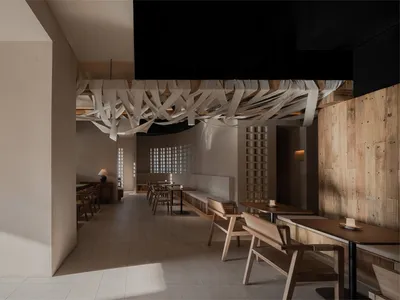 Interior design of a minimalist restaurant featuring wooden materials.