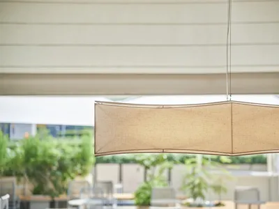 A modern coffee shop with a fabric lamp shade hanging from the ceiling, enhancing the interior design and ambiance of the spa