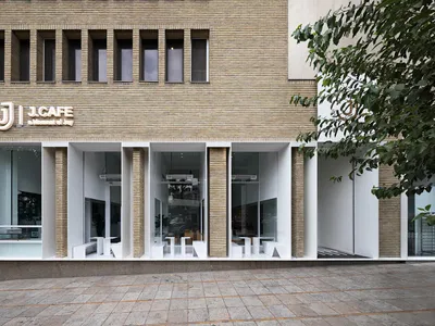 Modern restaurant exterior with brick-clay facade and large glass windows.