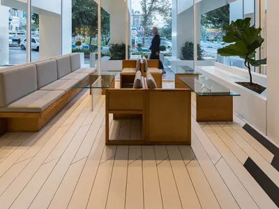 Modern restaurant interior with white concrete, wood, and glass elements.