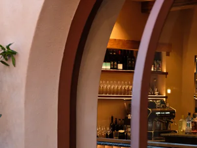 A modern restaurant bar with brick walls and concrete counter, showcasing sleek design elements and contemporary aesthetic.