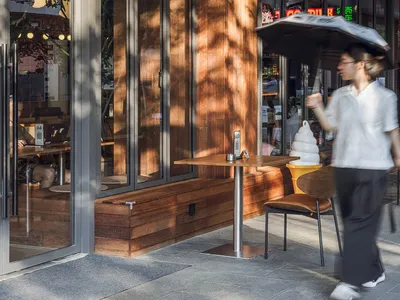A modern restaurant exterior with wooden and glass elements.