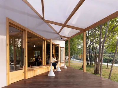 Restaurant exterior with modern pergola and transparent roof, designed with wooden elements.