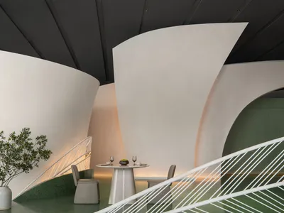 A modern restaurant with concrete and adobe walls, featuring a table setup with two chairs.