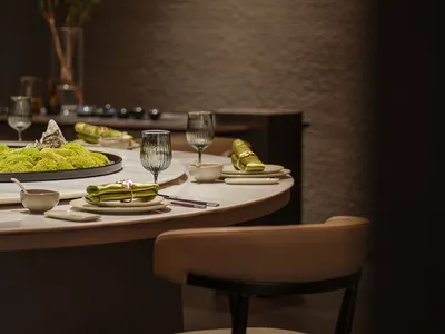 A modern restaurant interior with elegant dining setup and green plants.