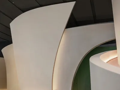 A minimalist modern restaurant interior with white concrete walls and a sleek dining table.