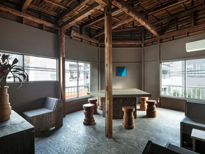 Modern industrial living room with wood furniture and exposed wooden beams on the ceiling.