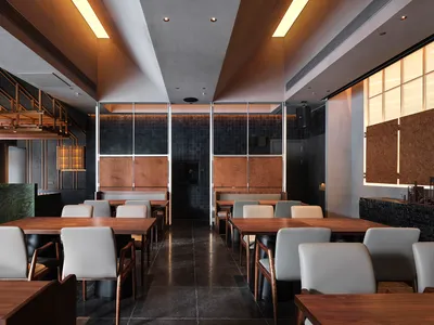 Modern industrial restaurant interior with marble accents and metallic finishes.