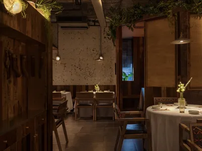 Industrial-style restaurant interior with wooden elements and greenery.