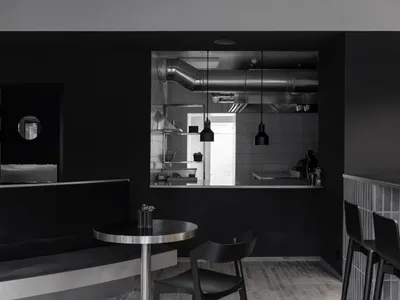 A minimalist restaurant interior featuring a black and metal design.