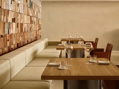 Modern restaurant interior featuring wooden tables and leather sofas