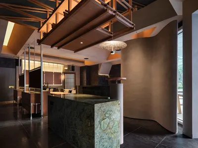 Modern minimalist restaurant interior with marble accents, metallic finishes, and wooden furnishings.