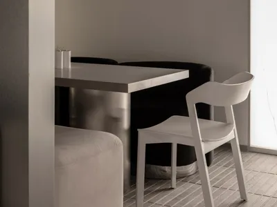 A minimalist modern restaurant setting featuring metal furniture and a sleek, clean aesthetic.
