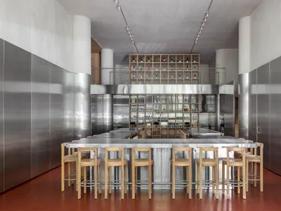 A modern restaurant interior featuring metallic and wooden materials.