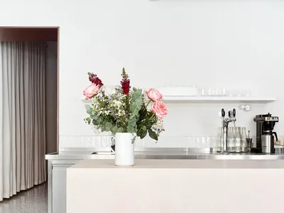 Floral arrangement on a modern restaurant countertop with concrete material and minimalist design.