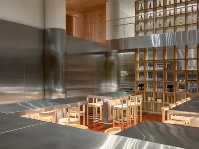 Interior of a modern minimalist restaurant with metal walls and bar stools