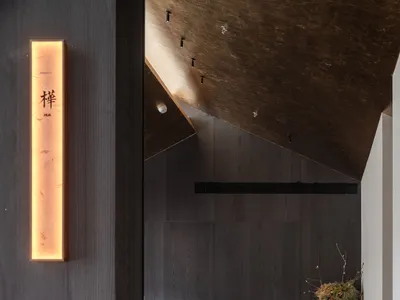 A minimalist restaurant interior with dark wood finishes and a sleek, modern design.