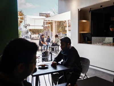 A modern cafe space with concrete seating, industrial-style design, and minimalist aesthetic.