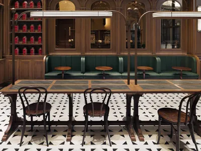 A modern restaurant bar with wooden tables, metal railings, and glass displays.