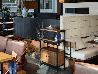 Modern cafe interior featuring wooden furniture and concrete walls